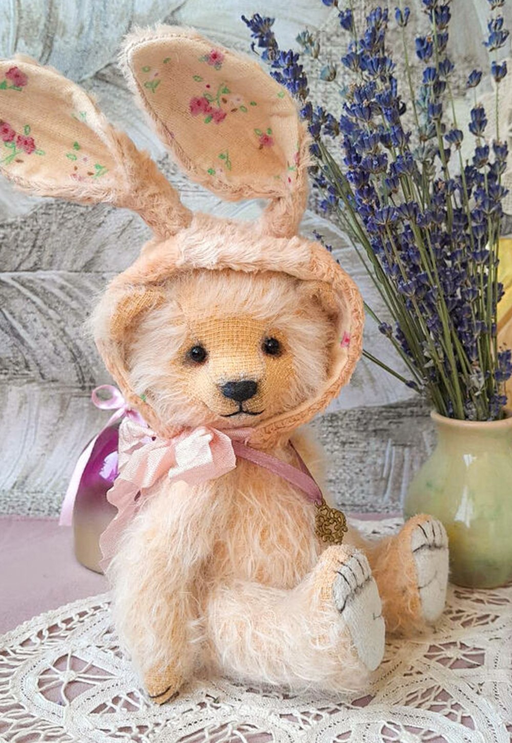 Lucie, a handmade mohair teddy bear dressed in a bunny bonnet